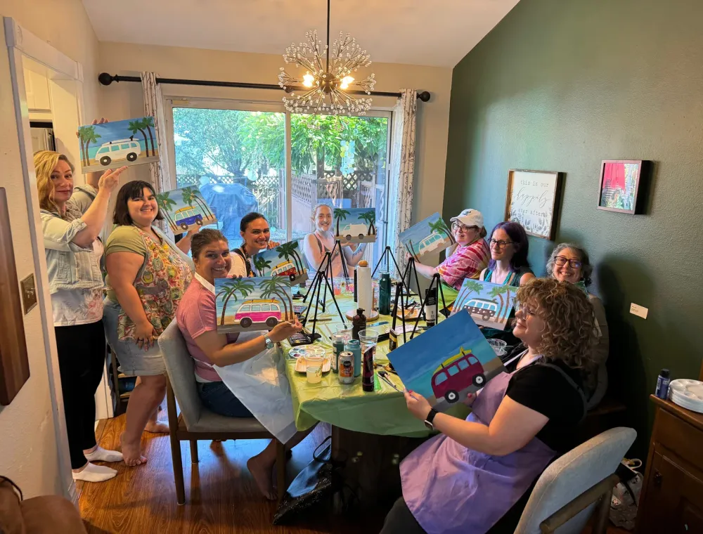 Friends painting colorful canvases together at a home party