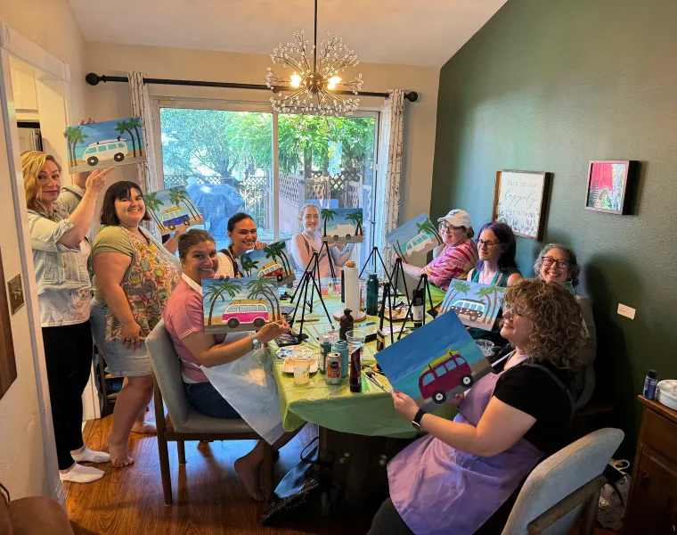 Friends gathered around a table for a painting party at home