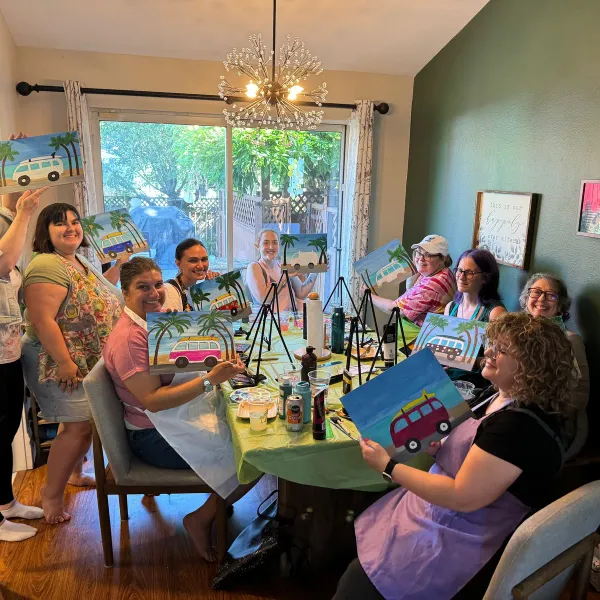 Friends painting colorful canvases together at a home party