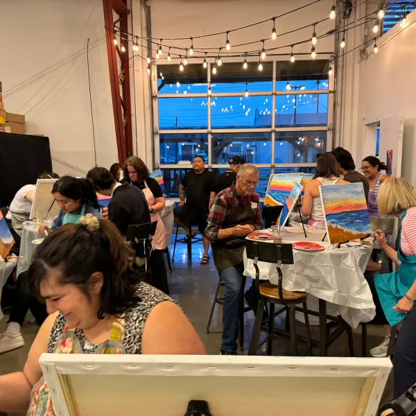Guests painting together at a lively evening event