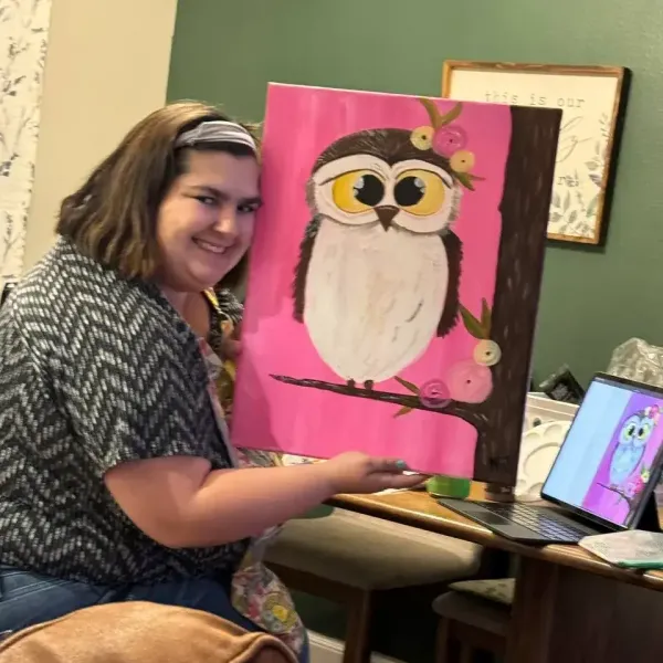 Nikky holding a finished pink owl painting