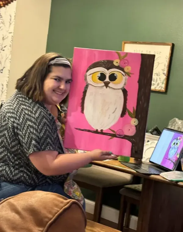 Nikky holding a finished pink owl painting